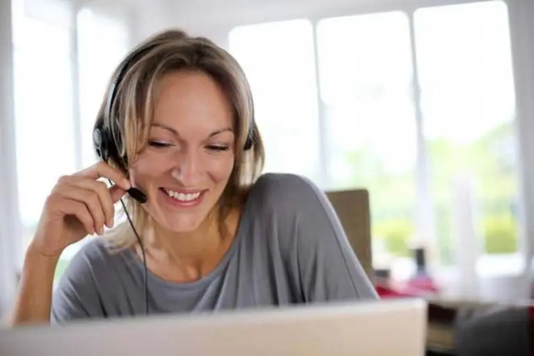 Frau sitzt vor einem Computer und Erhalt eine Visumsberatung über Skype