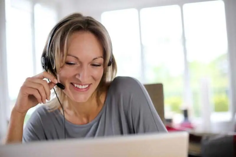 Frau sitzt vor einem Computer und Erhalt eine Visumsberatung über Skype