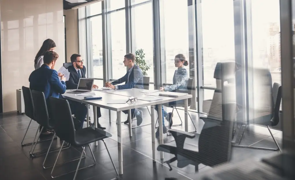 Fünf Personen bei einer Besprechung in einem Büro